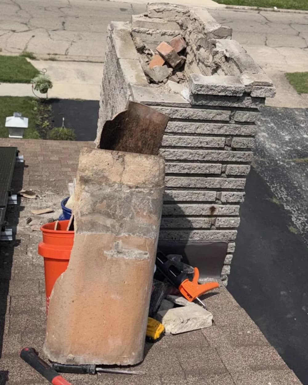 The chimney top opened around the flue with tools positioned on the roof