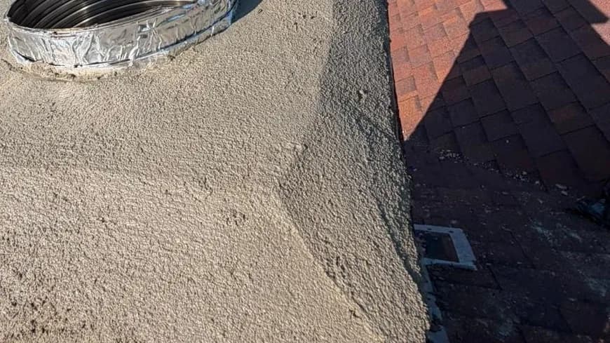 A freshly poured chimney crown with a stainless liner top plate sealed into it