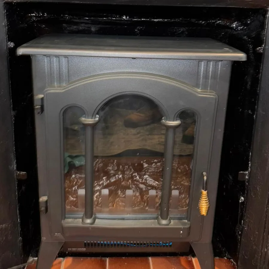 After: A fireplace opening masked with painter's tape and its sooty firebrick exposed, and the same opening finished with a stove standing in it