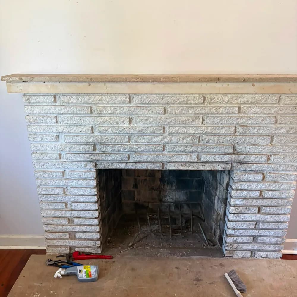 Before: A cleared fireplace opening with the firebox exposed, and the same fireplace finished with an arranged log set